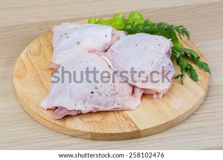 Raw chicken thighs with salad leaves and ruccola