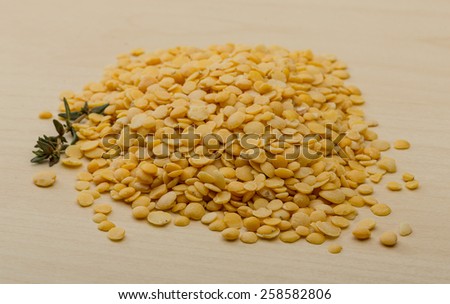 Yellow lentils heap on the wood background