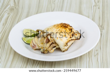 Grilled cuttlefish with lime on the wooden background