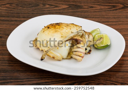 Grilled cuttlefish with lime on the wooden background