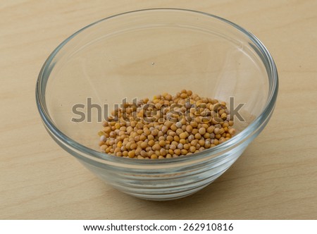 Yellow Mustard seeds on the wood background