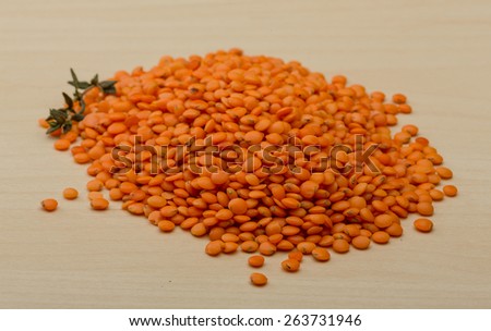Orange lentils heap on the wood background