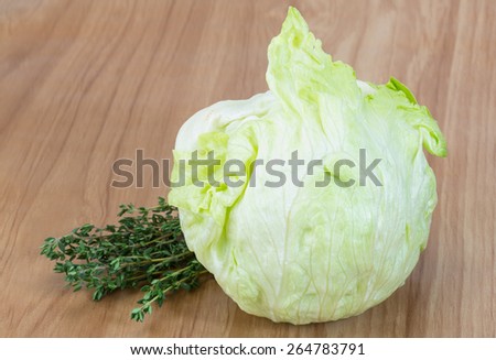 Fresh Iceberg salad with thyme herbs on wood background