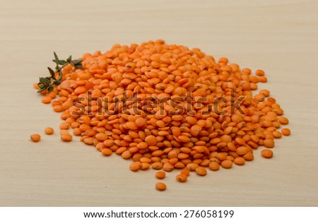 Orange lentils heap on the wood background