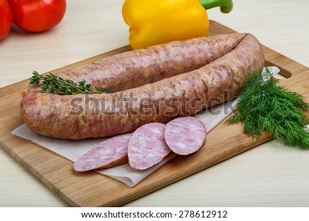 Smoked sausages with dill on the wood background