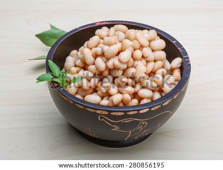 White canned beans in the bowl with herbs