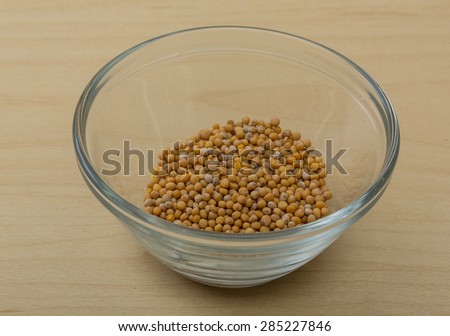 Yellow Mustard seeds on the wood background