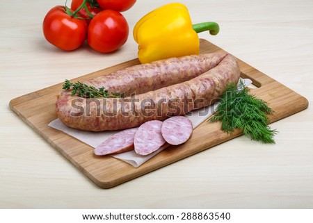 Smoked sausages with dill on the wood background