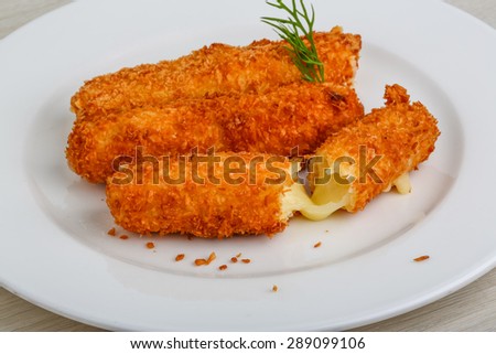 Fried cheese sticks in pan with dill