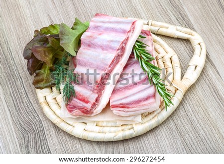 Fresh raw Lamb ribs with rosemary on the wood background