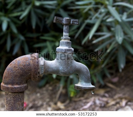 old rusty water tap with one water drop