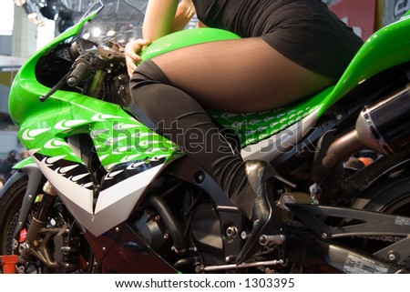 The perfect gift. Woman sit on motorbike. Woman leans her hand on her leg. Fishnet. Nice legs.