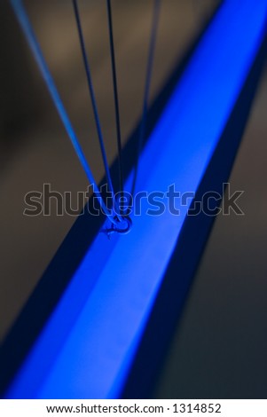 Hanging bar and support wires in blue neon light.