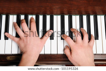 the hands of a pianist in action on piano in a plan