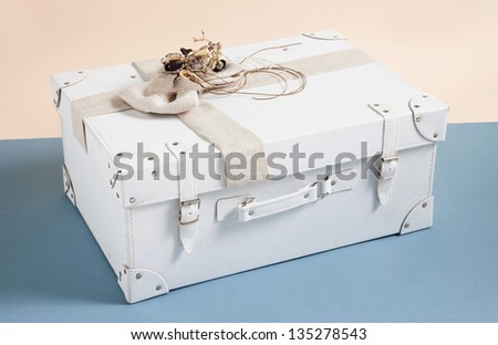 leather box for baptismal clothes for boy with motorcycle and ribbon on beige and blue background