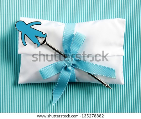 white baptism sugared almonds for boy with child and blue ribbon on striped blue background
