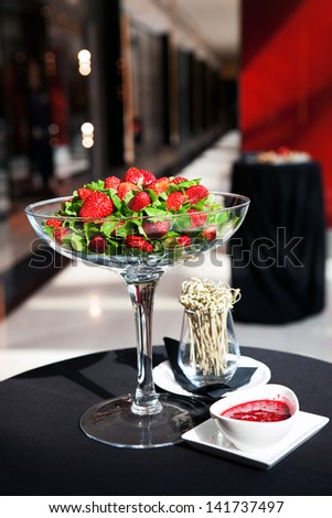 bowl with strawberries and strawberry sauce on blur background