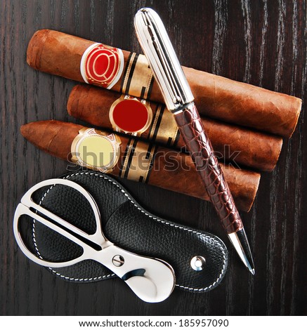 composition cigars, pen and cigar cutter scissors with case on table