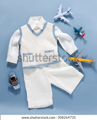 baptism boy clothes in plan with toys on a blue background