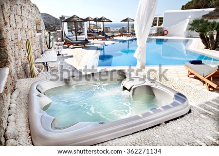 jacuzzi with a swimming pool in background