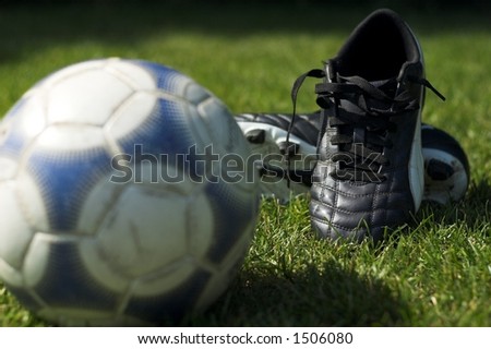 Soccer boots in focus with out of focus soccer ball in foreground