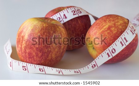 Three apples with measuring tape