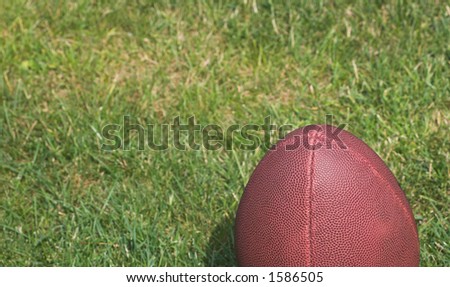American football against a grass background