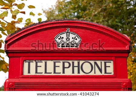 Close up of an old English red telephone box during autumn