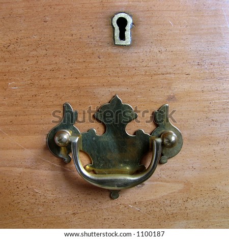 Antique drawer handle and lock on an old pine chest of drawers