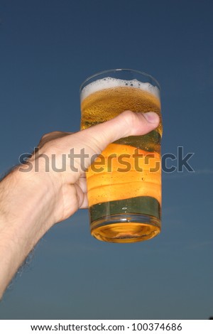 hand cheers beer up to the sky............................
