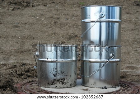metal silver cans on ground on a building site