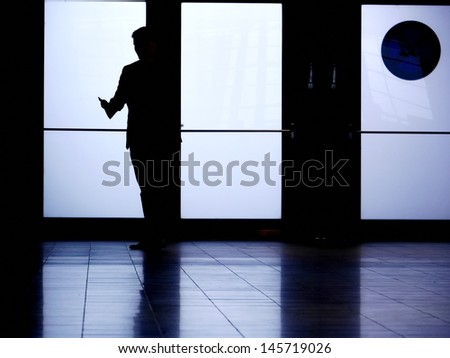 the silhouette of a man who is phoning.
