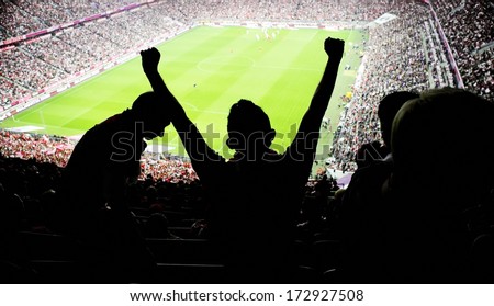 Silhouettes of fans celebrating a goal on football match