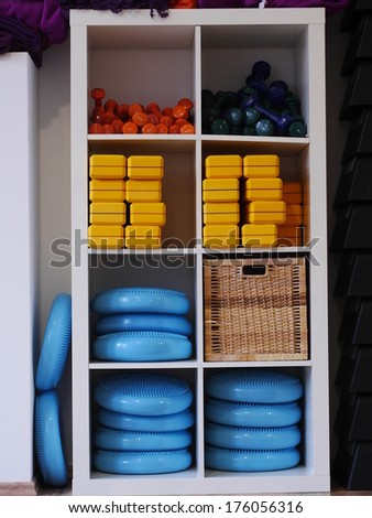 Sports gear in a storing rack in a gym.
