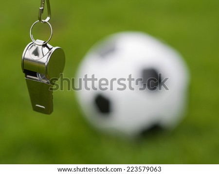 referee whistle in front of soccer ball