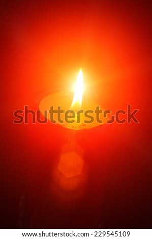 Closeup of burning candle isolated on black background