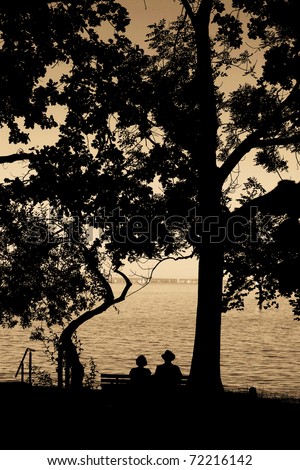 an elderly couple enjoying their retirement on a bench......