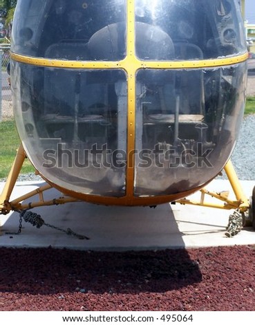 face of yellow military helicopter on landing pad