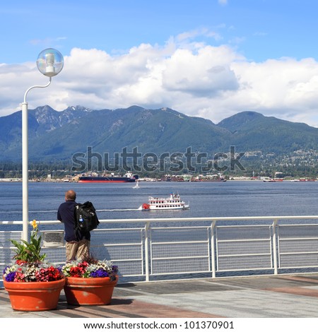 View on Vancouver bay and a tourist looking at. Vancouver, British Columbia. Canada