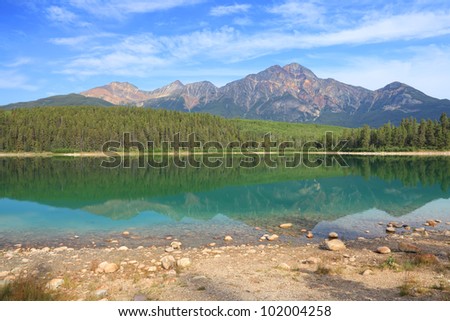 Pyramid mountain and lake with reflection on the smooth water. Jasper National Park, Alberta, Canada