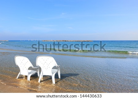 Morning on the sea. Two not occupied beach chairs on perfect beach of the Mediterranean sea.