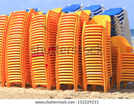Beach chairs and the chaise lounges, stored one on one at the Mediterranean beach
