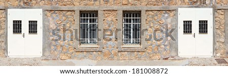 Stone wall with the closed doors and windows panorama