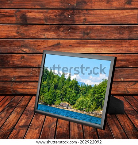 Picture frame with rocky coast of the Pacific Ocean landscape (Vancouver island, British Columbia, Canada) on the wooden panel background. Collage of my photos