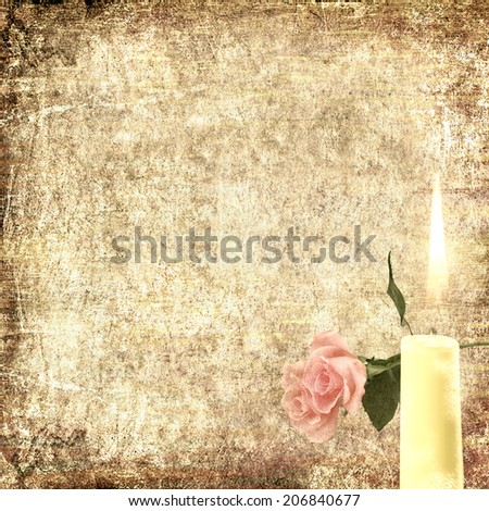 Textured old paper background with rose flower and burning candle. Copy space is available