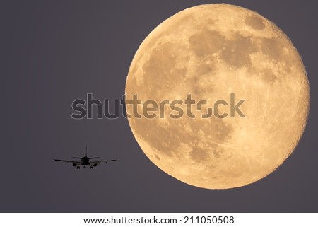 Landing plane on a full moon background