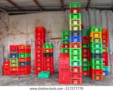 Stacked fruit packing containers. Colorful boxes plastic crates. Packing containers piles at fruits and vegetable storage