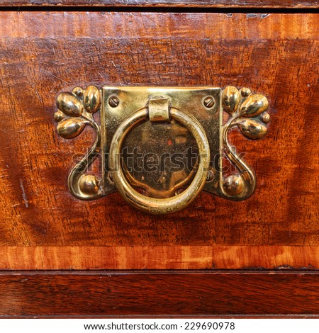 Decorative engraved copper ring of furniture's handle antique wood  background