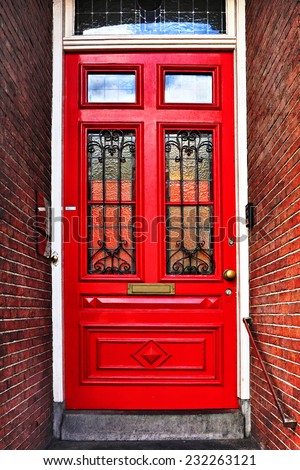 Red wooden glass door of a red brick classical building, Europe. Architectural theme. Photo in retro style. Paper texture. Aged textured photo in retro style
