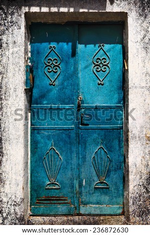 Blue metal forged door of sandstone traditional building, Middle east. Architectural theme. Photo in retro style. Paper texture. Aged textured photo in retro style